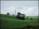 een alpeweide met kerk in het Jura